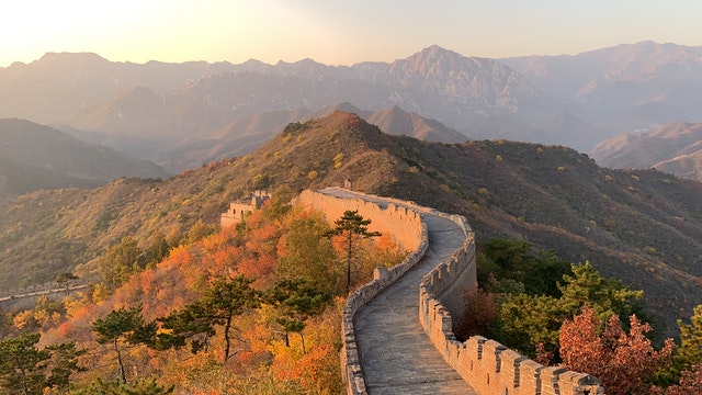 Foto ilustando a grande muralha da china em uma paisagem montanhosa